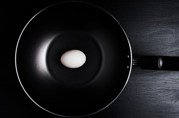 single white egg in a frying pan