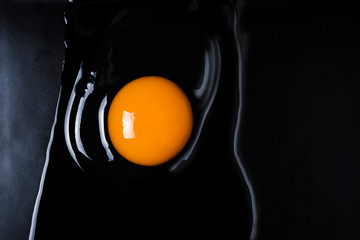 Egg and shell cracked on a black plate © artpritsadee