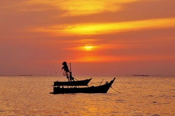 silhouette of fisherman boat with during sunset in Thailand