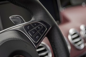 Control buttons on steering wheel. Car interior detail.