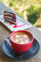 Red cup coffee in morning time with cake