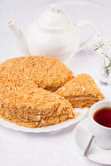 cake Napoleon and kettle with tea