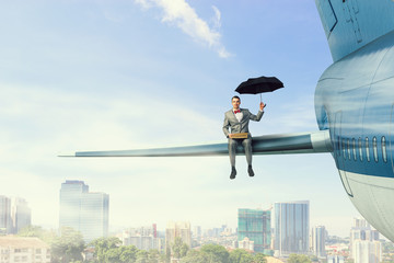 Fototapeta premium On wing of flying airplane . Mixed media