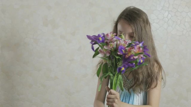 Beautiful girl rejoices donated bouquet of flowers and swirls.
