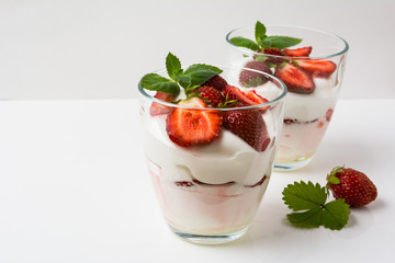 Layered strawberries dessert with cream cheese on white backgrou
