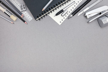 gray desktop with notebook, pencils and various drawing tools, t
