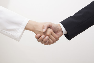 握手する医者とビジネスマン