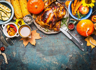 Festive Thanksgiving Day food background with roasted whole turkey or chicken and sauce, harvest...