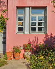 Fototapeta na wymiar colorful house window and yard with flowers and plants, Athens Greece