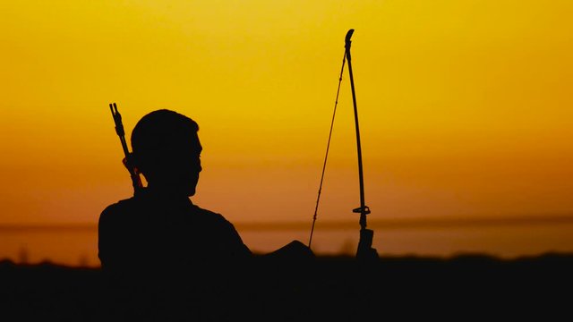 Archery silhouette, sun sets behind the archer/ Archery silhouette, sun sets behind the archer. A young man shoots a bow.