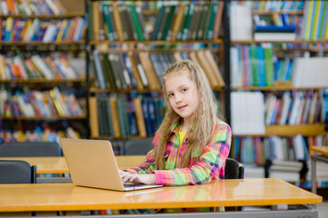 Young female student with laptop in library