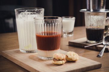 Thai Tea comes in a milk glass of cold , and syrup on a wooden t