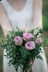 Bride holding wedding bouquet, bunch of fresh cut flowers.