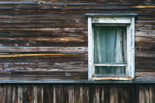 Old window in wooden residential building.