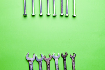The image of keys and screws on a green background