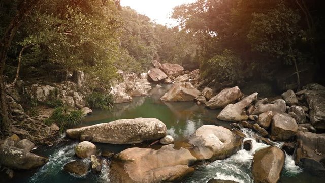 Peaceful waters of a babbling brook flow amongst boulders through a tropical rainforest near Nha Trang, Vietnam, with sound. UltraHD 4k footage