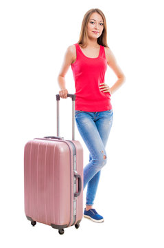 Young attractive woman in blue jeans with a suitcase isolated on white background.