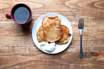Potato pancakes and tea on a wooden table. Background