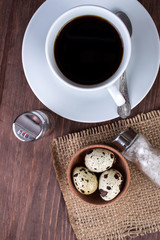 Dietary breakfast: quail eggs, oatmeal, hot drink on a wooden table. Flat lay.