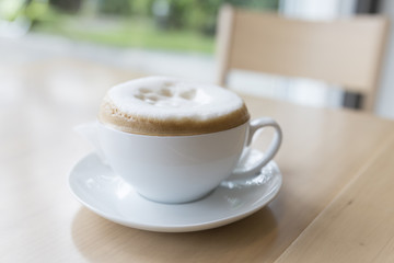 hot cappuccino coffee on wooden desk