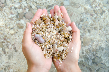 background of hands keeping little pebble stones on the beach