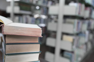 old book on wooden table with blur library background