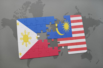 puzzle with the national flag of philippines and malaysia on a world map background.