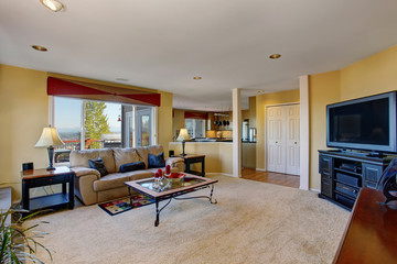 Cozy living room with yellow walls. view of kitchen