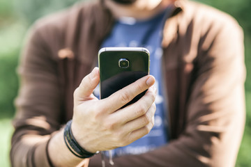 Man's hand holding mobile smartphone, young businessman at work