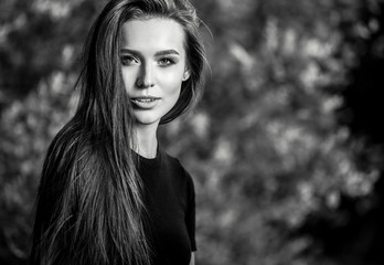 Naklejka premium Outdoors black-white portrait of beautiful young long hair brunette woman.