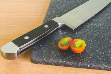 knife on a chopping board the cut tomato/kitchen knife on a chopping board the tomato cut red with...