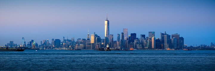 Fototapeta premium Panoramic Lower Manhattan Financial District skyscrapers and New York City Harbor at twilight