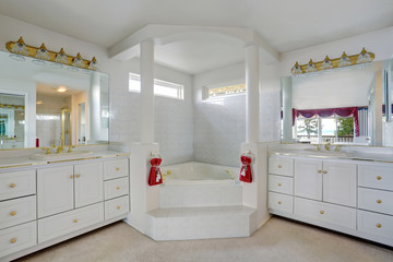 Luxury large white master bathroom cabinets with double sinks and big bath tub.