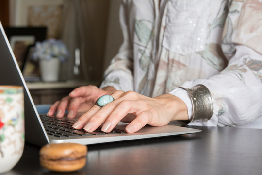 Woman hands writes a pen in a notebook, computer keyboard