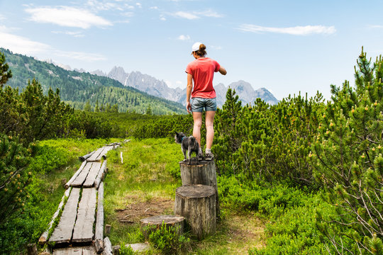 Young girl enjoying panoramic view through a forest to the mountain range