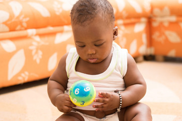 b&eacute;b&eacute; curieux tenant une petite balle dans les mains