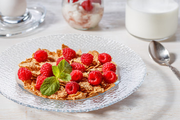 Wheat flakes with raspberries and milk.