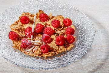Wheat flakes with raspberries and milk.