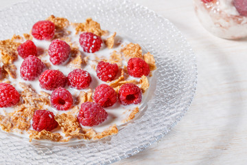 Wheat flakes with raspberries and milk.