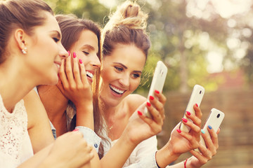 Happy group of friends with smartphones