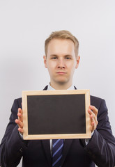 Junger Mann im Anzug mit Tafel f&uuml;r Text zur Werbung