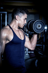 Young man exercising in dark and old gym