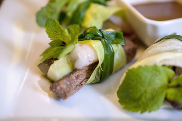 Asian Fresh Rolls on the white plate with sauce and green mint