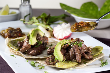 Mexican taco gourmet accompanied by avocado