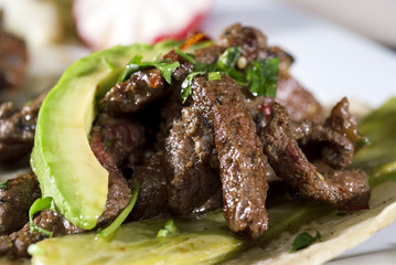 Mexican taco gourmet accompanied by avocado