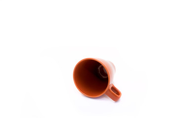 Overturned ceramic cup on the white background