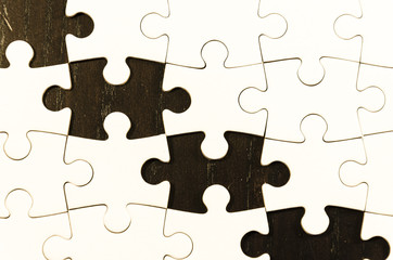 Fototapeta premium fill the gaps, white jigsaw/puzzle white one gap over black wooden table background, symbol of problem solving
