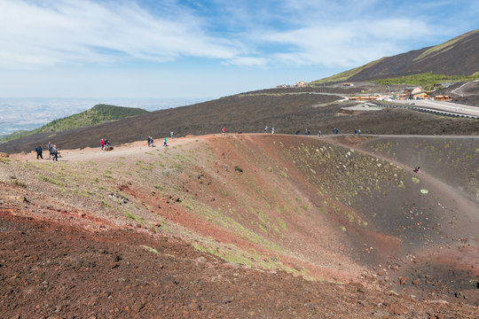 Tourists walking around Silvestri crater of Mount Etna, Italy
