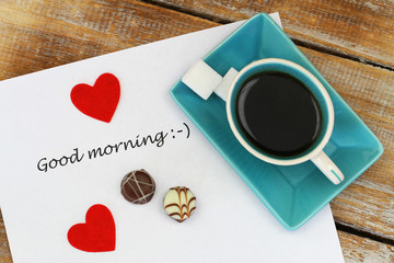 Good morning written on white paper with red hearts and round chocolates   © graletta