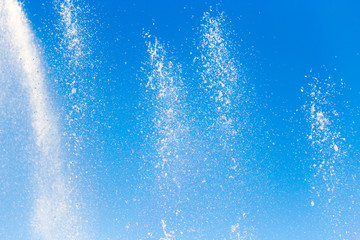Naklejka na ściany i meble water splashing from the fountain in the background of blue sky
